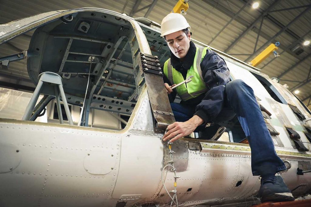 Ensure Quality Aviation Equipment. A worker repairing a plane hull.